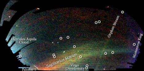 SDSS Field of Streams A map of stars in the outer regions of the Milky Way Galaxy, derived from the SDSS images of the northern sky, shown in a Mercator-like projection. The color indicates the distance of the stars, while the intensity indicates the density of stars on the sky. Structures visible in this map include streams of stars torn from the Sagittarius dwarf galaxy, a smaller 'orphan' stream crossing the Sagittarius streams, the 'Monoceros Ring' that encircles the Milky Way disk, trails of stars being stripped from the globular cluster Palomar 5, and excesses of stars found towards the constellations Virgo and Hercules. Circles enclose new Milky Way companions discovered by the SDSS; two of these are faint globular star clusters, while the others are faint dwarf galaxies. Credit: V. Belokurov and the Sloan Digital Sky Survey.